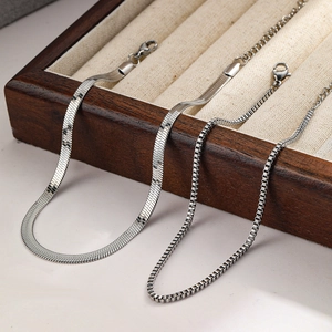 Detail of silver herringbone and box chain anklets with lobster clasp on a display tray