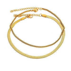 Dual layer gold stainless steel jewelry set featuring a flat snake chain and box chain