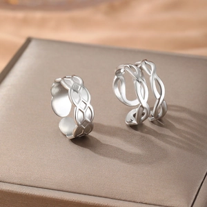 Silver woven geometric and hollow intertwined open rings on premium silk background