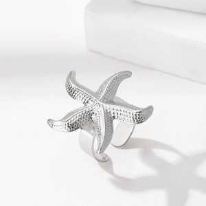 Détail d'une bague étoile de mer argentée avec surface texturée et anneau ouvert ajustable