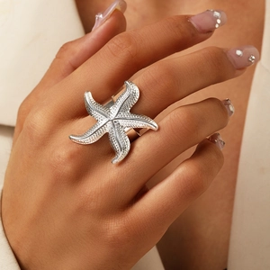 Vue détaillée d'une bague étoile de mer argentée texturée portée sur le doigt