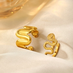 Macro de bagues dorées ondulées et texture serpent sur tissu satiné luxueux