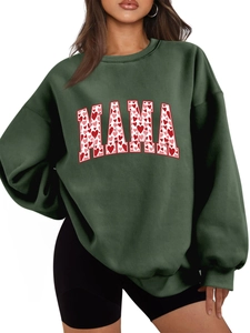 Detail of MAMA lettering with red heart pattern on green oversized crewneck sweatshirt