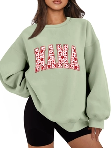 Detail of sage green MAMA sweatshirt featuring colorful heart patterns within the text