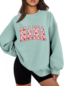Detail of mint green sweatshirt featuring MAMA lettering with red and pink hearts