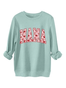 Detail of mint green sweatshirt with MAMA text and colorful heart patterns