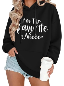 Detail of white text print and heart pattern on a black oversized hooded sweatshirt