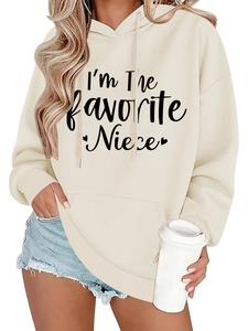 Close-up of I'm The favorite Niece print on a beige hoodie with frayed denim shorts