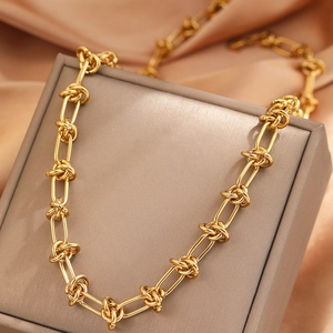 Gold knotted link necklace in chunky industrial style over premium satin fabric