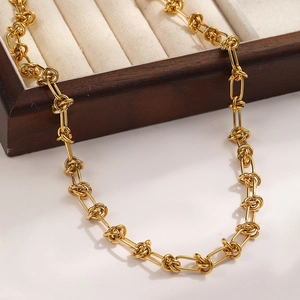Close-up of golden double-strand knotted chain necklace in a vintage wood jewelry box