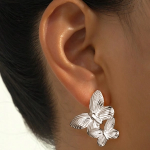 Detailed close-up of butterfly earrings with radiant texture on silver stainless steel