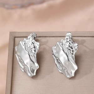 Polished stainless steel stud earrings with irregular lava texture on jewelry box