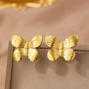 Vintage French style gold butterfly stud earrings on a premium jewelry box edge