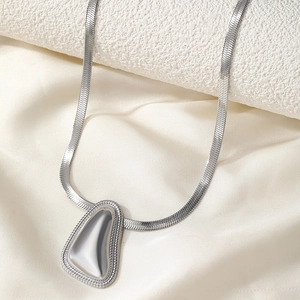 Collier minimaliste en acier inoxydable avec pendentif goutte sur fond soie et pierre