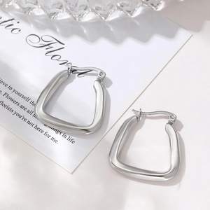 Minimalist silver U-shaped stainless steel earrings on a decorative white card