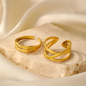 Detailed close-up of double layered gold geometric rings on natural stone and silk