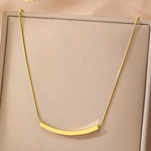 Elegant gold smile curved bar necklace with minimalist snake chain on jewelry display
