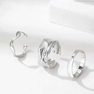 Detailed view of three-piece silver-toned irregular textured and smooth minimalist rings