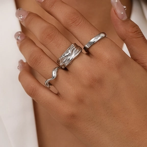 Three-piece silver ring set featuring irregular lava texture and wave designs on hand