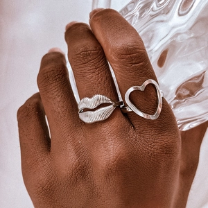 Close-up of minimalist silver stainless steel heart and lip textured ring set for women
