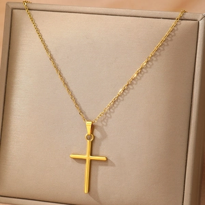 Minimalist gold cross necklace on display stand with polished metal pendant and slim chain
