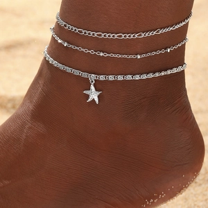 Bohemian silver layered anklet set with starfish pendant on a sunny beach background