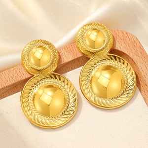 Vintage golden tiered circular drop earrings with textured details on cream satin background