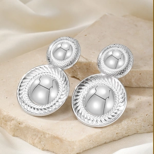 Detailed view of silver statement earrings with spiral radial patterns on stone and silk