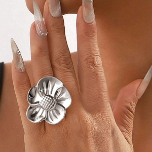 Close-up of oversized silver flower ring with intricate grid texture on hand