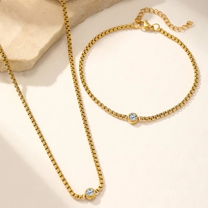 Detail of gold-plated stainless steel jewelry set featuring bezel-set round crystals