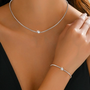 Detail view of gold-plated stainless steel jewelry set with round solitaire crystals