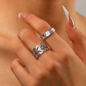 Detailed view of leaf shaped open ring and textured band on hand for women