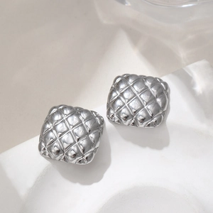 Elegant silver square quilted metal earrings with textured relief on stone display