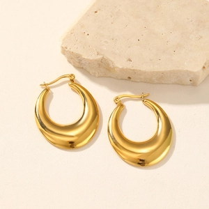Detailed view of chunky golden teardrop hoop earrings with high-polish mirror finish