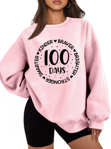 Close-up of pink crewneck sweatshirt with KINDER BRAVER 100 DAYS slogan print