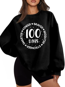 Close-up of black drop shoulder sweatshirt featuring white Kinder Braver print detail