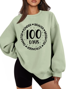 Detail of light green sweatshirt featuring black Kinder Braver 100 Days printed graphic