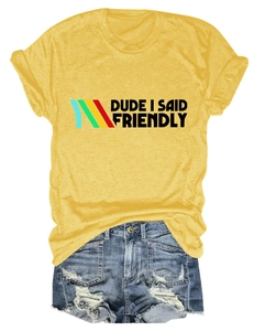 Detail of yellow graphic tee with 'DUDE I SAID FRIENDLY' text and ripped denim shorts