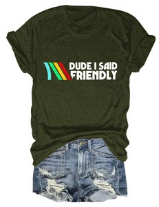 Flat lay of dark green T-shirt with 'DUDE I SAID FRIENDLY' text and denim shorts