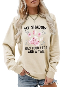 Dettaglio felpa girocollo color albicocca con testo 'My Shadow Has Four Legs' e zampa