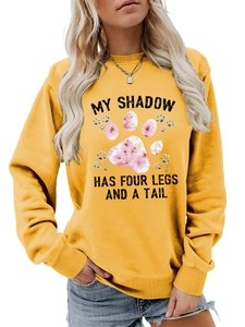Dettaglio felpa gialla girocollo con stampa My Shadow Has Four Legs e polsini a costine