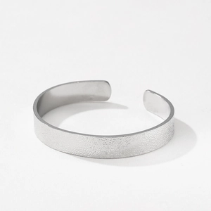 Minimalist wide open cuff bracelet with a textured silver-tone finish and brushed metal style