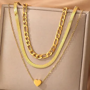 Three-layer gold necklace featuring heart pendant, figaro and snake chain styles