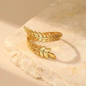 Macro detail of golden leaf open ring with matte finish on natural stone base