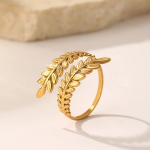 Detailed close-up of golden olive leaf branch texture on an adjustable stainless steel ring