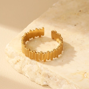Detail of gold-plated geometric open ring with vertical stripes and wavy edge texture
