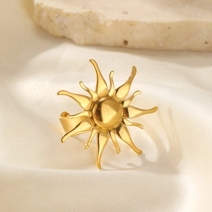 Nahaufnahme des goldenen Sonnenblumenrings auf weißer Seide mit sanftem Licht