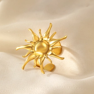 Detailansicht des goldenen Sonnenblumen-Rings auf beigem Seidenstoff mit Matt-Effekt