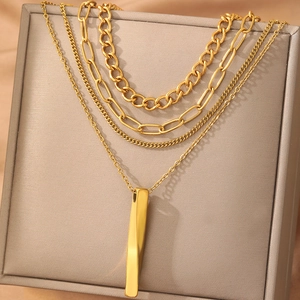 Ensemble de colliers superposés dorés avec pendentif barre torsadée et maillons mixtes