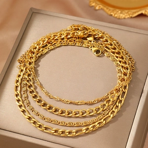 Set of 4 gold layered ankle chains with Figaro and curb links on jewelry display